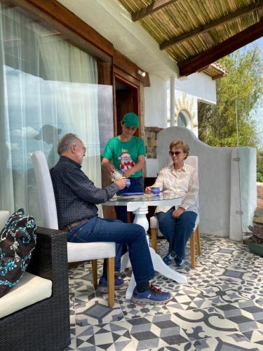 a group of people sitting at a table on a patio at Cabaña Malaquita Suite - Hotel Seilan Alojamiento Rural in Paipa