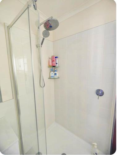 a shower with a glass door in a bathroom at Three Bedrooms Hermay Cottage with Free Parking and 5 minutes drive to Launceston near museum in Invermay