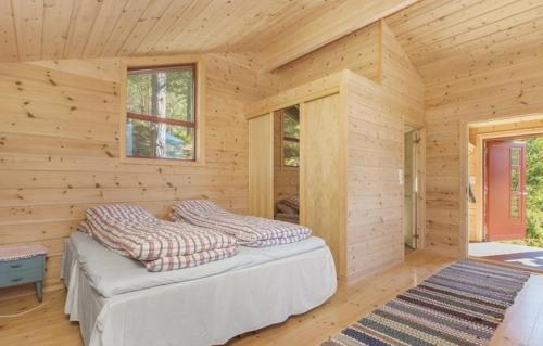 Cabaña de madera con cama en una habitación en Flott hytte med panoramautsikt og privat strand, en Stavang