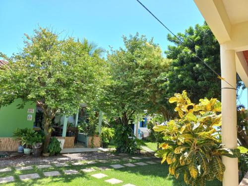 a yard with trees and a house at Pousada Cajueiro in Itaúnas