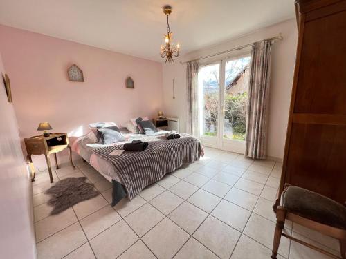 a bedroom with a bed and a large window at MAISON DES VIGNES in Embrun