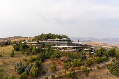 a building on top of a hill with trees at Ananti Resort & Spa in Tríkala