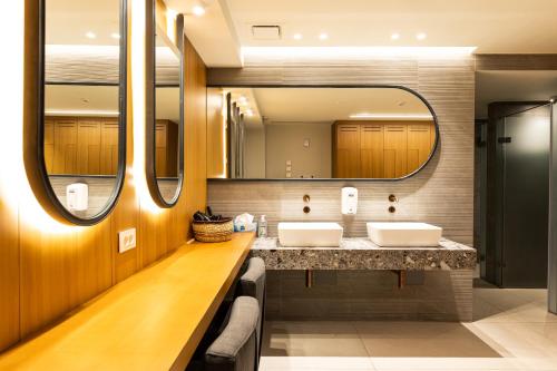 ein Badezimmer mit zwei Waschbecken und einem großen Spiegel in der Unterkunft Ananti Resort & Spa in Tríkala