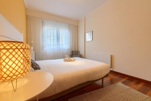 Un dormitorio con una cama blanca y una ventana. en Museo Arte by Next Stop Bilbao, en Bilbao