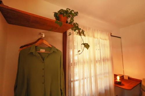 a green shirt hanging in a room with a window at Casa Örüm in Florianópolis