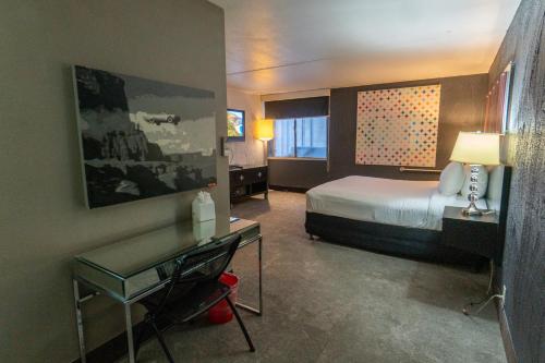 フェニックスにあるThe Clarendon Hotel and Spaのベッドとデスクが備わるホテルルームです。