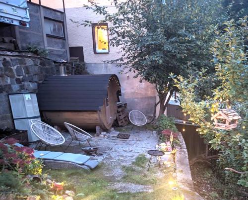 a backyard with chairs and a table and a house at F1 - Urlaubsmagie - Helle Wohnung mit Sauna & Pool in Sebnitz