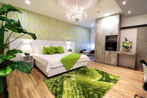 1 dormitorio con cama y alfombra verde en Luma Plaza Hotel, en Pereira