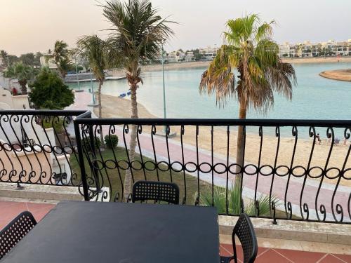 a table and chairs on a balcony with a view of the water at شاليه ثلاث غرف نوم في درة العروس in Durat  Alarous