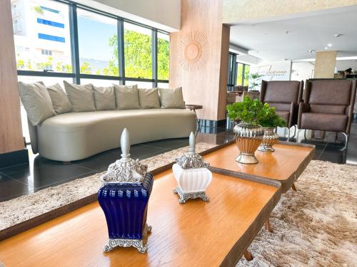 a living room with a couch and a table at Vivence Suítes Hotel Palmas in Palmas