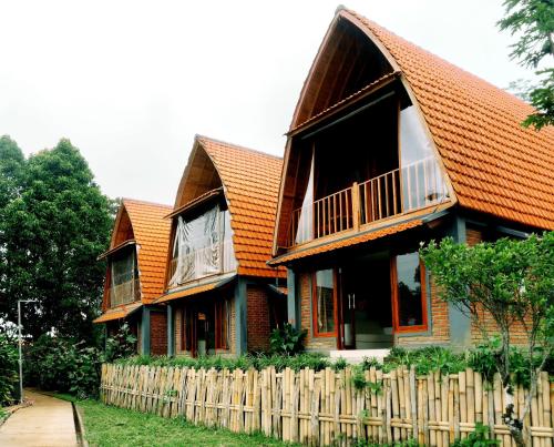 Camaradvipa Retreat Munduk في موندوك: منزل به سقف برتقالي وسياج