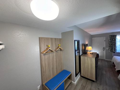 a room with a bed and a blue bench at Days Inn by Wyndham San Marcos in San Marcos
