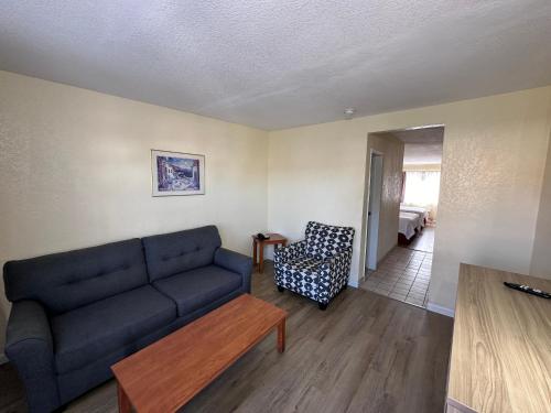 a living room with a blue couch and a chair at Days Inn by Wyndham San Marcos in San Marcos