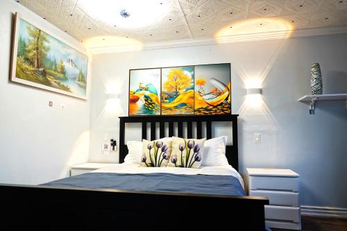 a bedroom with a bed with paintings on the wall at Renovated Cozy Bedroom with Private washroom in Toronto