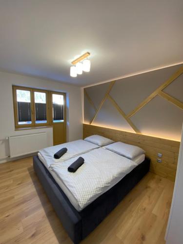 a bedroom with a bed with two shoes on it at Chata Petra in Oravský Biely Potok