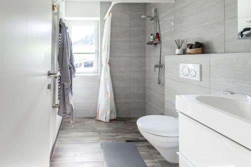 a white bathroom with a toilet and a sink at casa Battilana Li Curt - Poschiavo in Prada