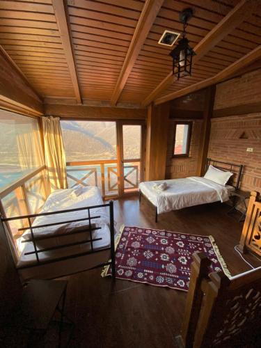 a large room with two beds and a balcony at Hotel Ananuri in Ananuri