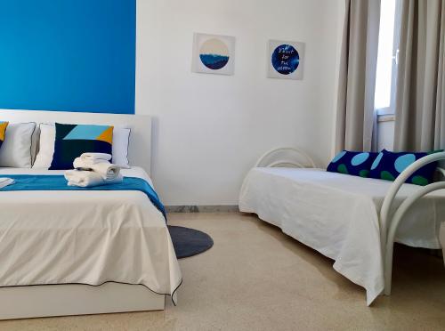 two beds in a room with blue and white at Casa Vacanze Dolce Chiara in Acquarica