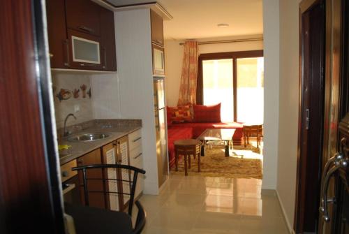 a kitchen with a sink and a living room at Apartamentos Bchraya in Laayoune