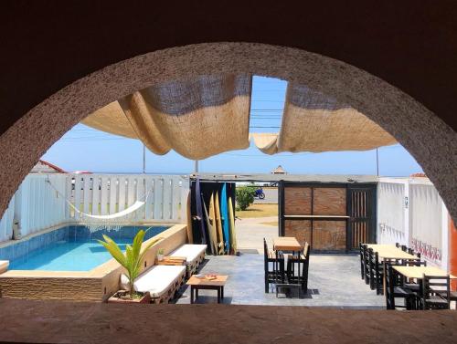 an arch over a patio with a pool and tables and chairs at Pointbreak Surf Camp in Huanchaco