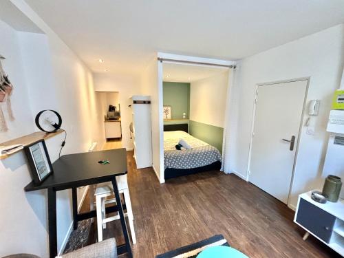 ムーランにあるAppartement cosy Centre villeのベッドとデスクが備わる小さな客室です。