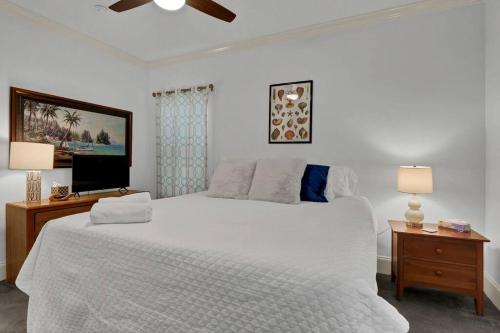 - une chambre blanche avec un grand lit et une télévision dans l'établissement Blue Ocean Bungalow, à Carolina Beach
