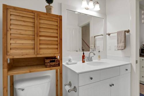La salle de bains est pourvue de toilettes, d'un lavabo et d'un miroir. dans l'établissement Blue Ocean Bungalow, à Carolina Beach