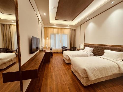 Habitación de hotel con 2 camas y TV de pantalla plana. en Noblestride Resort en Gangtok