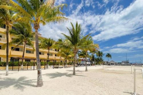 a row of palm trees in front of a building at Apartamento en complejo hotelero con playa in Cancún