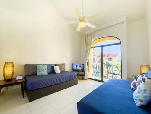 カンクンにあるApartamento en complejo hotelero con playaのベッドルーム1室(ベッド2台、ソファ、窓付)