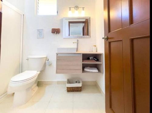 坎昆的住宿－Apartamento en complejo hotelero con playa，一间带卫生间、水槽和镜子的浴室