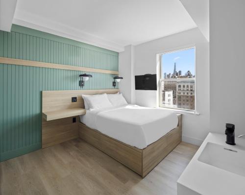 um quarto com uma cama grande e uma janela em Riverside Tower Hotel em Nova Iorque