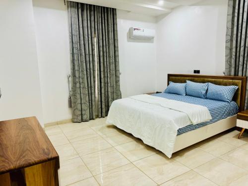 a bedroom with a bed with blue pillows on it at Luxury Villa within Abuja Sanctuary in Abuja