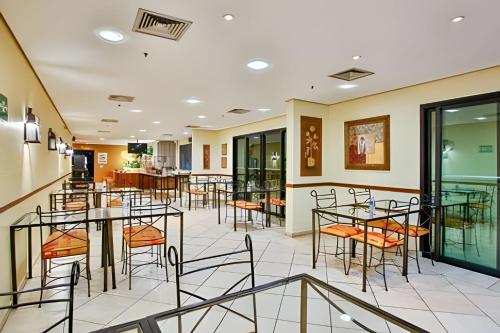 una zona de comedor con mesas y sillas en un restaurante en Flat Hotel Rua Americo Brasiliense 2163 Uh1208, en São Paulo