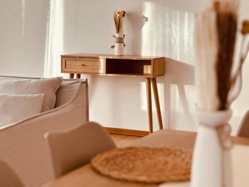a side table next to a couch with a vase at Auszeit im Grünen nahe der Heide in Winsen Aller