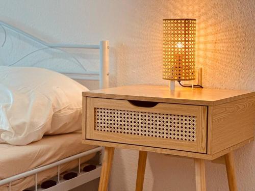 a nightstand with a lamp on it next to a bed at Auszeit im Grünen nahe der Heide in Winsen Aller
