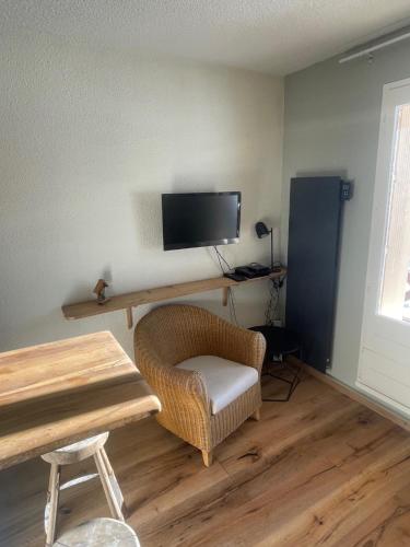 un salon avec une table, une chaise et une télévision dans l'établissement Studio shuss 5 Fou d’Allos, à Allos