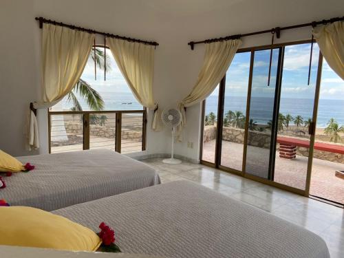 1 dormitorio con 2 camas y vistas al océano en VILLA SIEMPRE DOMINGO, en Tecuán