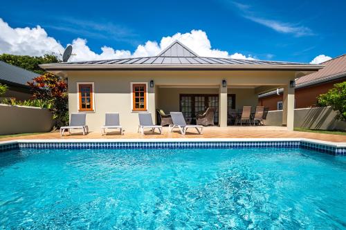 a house with a swimming pool in front of a house at Bram Villa in Canaan