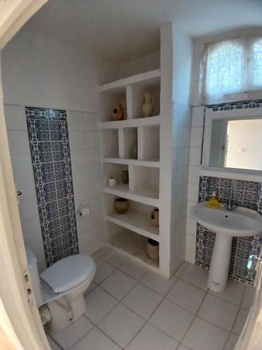 a bathroom with a toilet and a sink at Menzel Churasco Djerba in Aghīr