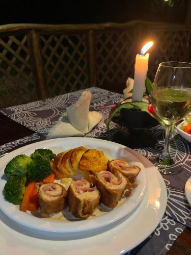 a plate of food on a table with a candle at Sacha Urco Lodge y Bosque Protector in Mindo