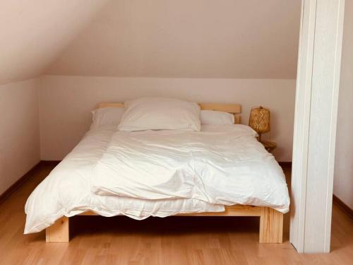 a bed with white sheets and pillows in a bedroom at Moderne Wohnung in der Heide in Winsen Aller