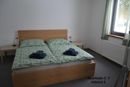 a bedroom with a bed with two blue slippers at Apartmány Benátky in Suchdol nad Lužnicí