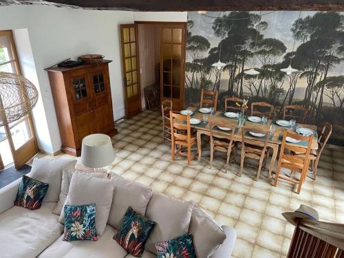 un salon avec un canapé, une table et des chaises dans l'établissement Maison familiale (10p) à 15 min du Zoo de Beauval, à La Vernelle