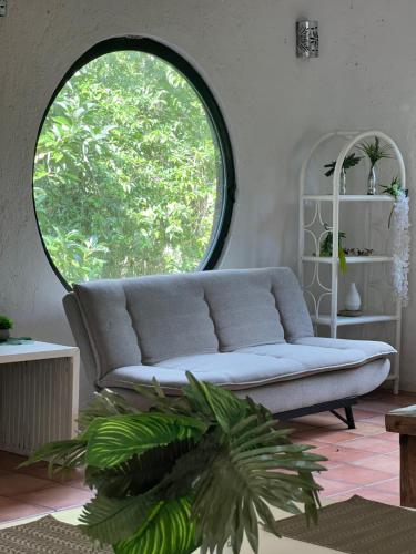 a living room with a couch and a large window at Playa Car house in Playa del Carmen