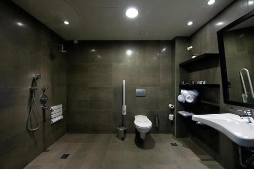 a bathroom with a toilet and a sink at Ananti Resort & Spa in Tríkala