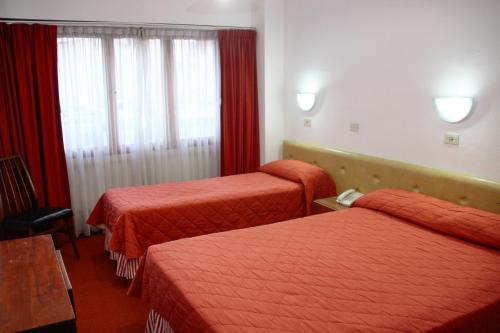 Habitación de hotel con 2 camas y ventana en Hotel Neptuno en Mar del Plata