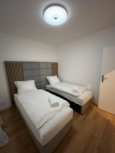 Habitación con 2 camas y una luz en el techo. en ANETT, en Sulęcin