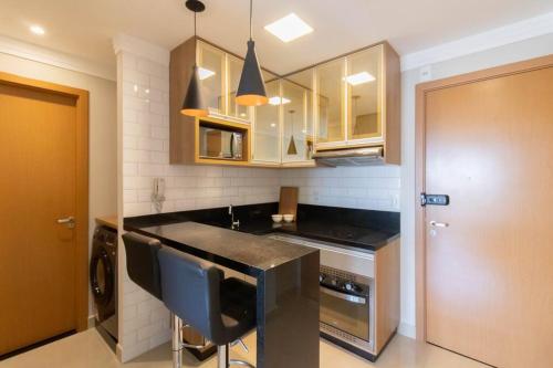 a kitchen with a black counter top and cabinets at Elegant Studio - GRU 1506 in Guarulhos