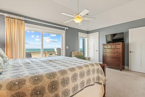 a bedroom with a bed and a view of the ocean at Cape Point Retreat 7 Bedroom Home by KEES Vacations in Buxton
